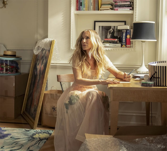 Sarah Jessica Parker sitting at a desk in a light dress, reflecting on And Just Like That series finale and fan reactions. Sarah Jessica Parker sitting at a desk in a light dress, reflecting on And Just Like That series finale and fan reactions.