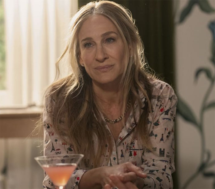 Sarah Jessica Parker seated indoors with a neutral expression, related to And Just Like That series finale response. Sarah Jessica Parker seated indoors with a neutral expression, related to And Just Like That series finale response.