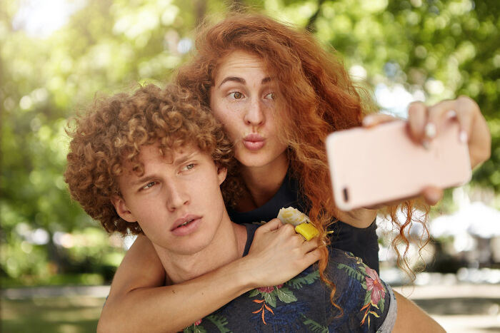 Young man and woman posing together outdoors, capturing a selfie with confident alpha vibe and playful expressions. - 15