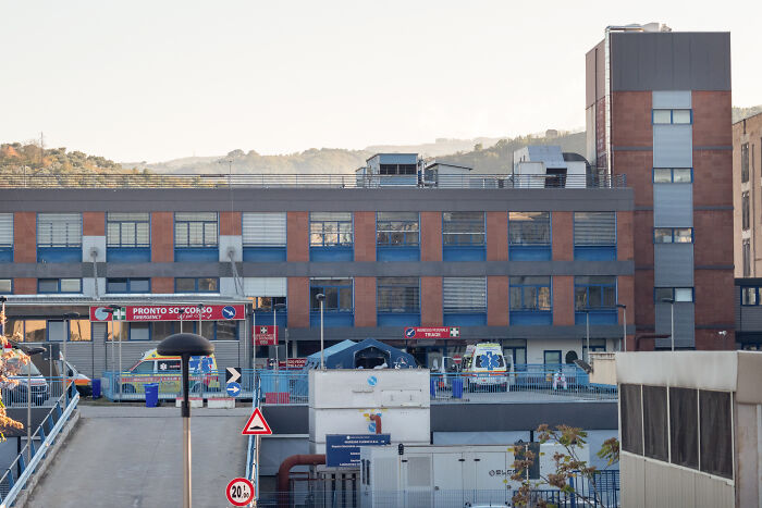 Hospital emergency entrance with ambulances parked outside as authorities investigate toxic broccoli sandwich case.