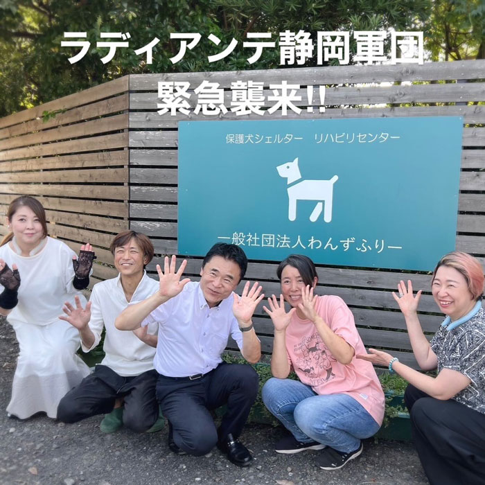 Group of people smiling and waving outside a pet shelter, highlighting dog saves life and pet shelter keywords.