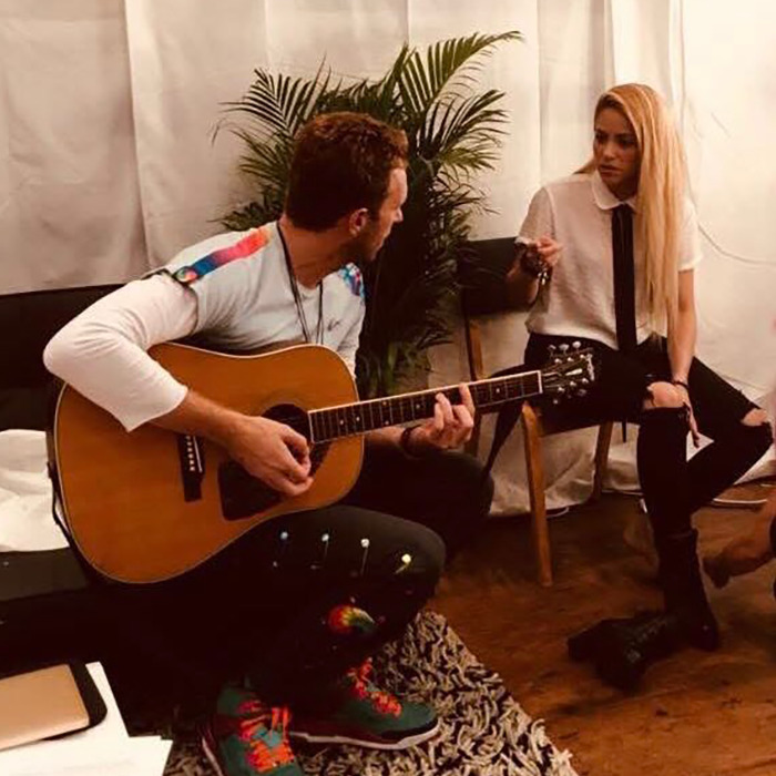 Chris Martin playing guitar while Shakira listens attentively, sparking fans speculate on Shakira and Chris Martin romance.