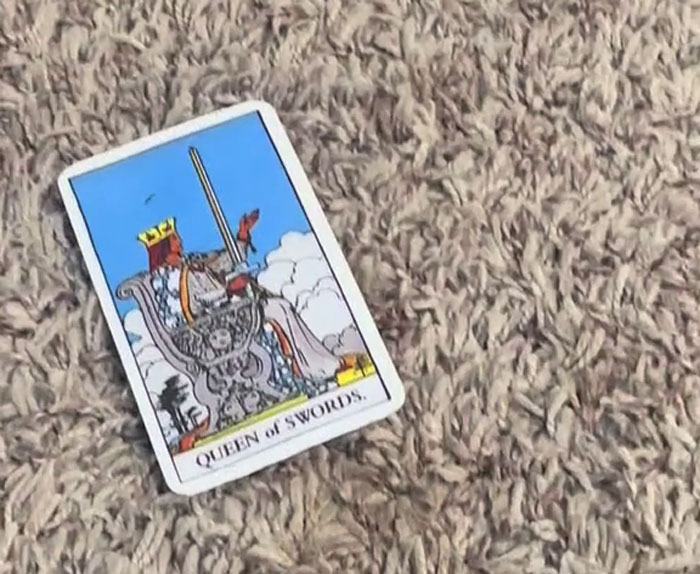 Tarot card Queen of Swords on carpet representing mystical talents linked to a black rescue cat mom’s story. Tarot card Queen of Swords on carpet representing mystical talents linked to a black rescue cat mom’s story.