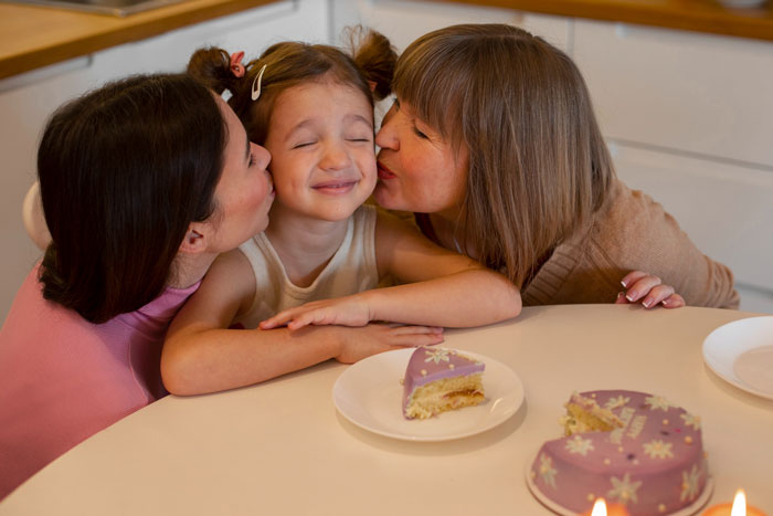 Woman and sister-in-law showing affection to niece on birthday, highlighting niece's special day over spiritual awakening.