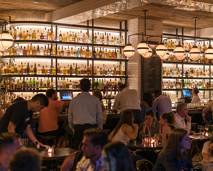 Crowded bar scene at night with people socializing, drinking, and sitting near a well-lit liquor shelf, highlighting dating red flags. Crowded bar scene at night with people socializing, drinking, and sitting near a well-lit liquor shelf, highlighting dating red flags.