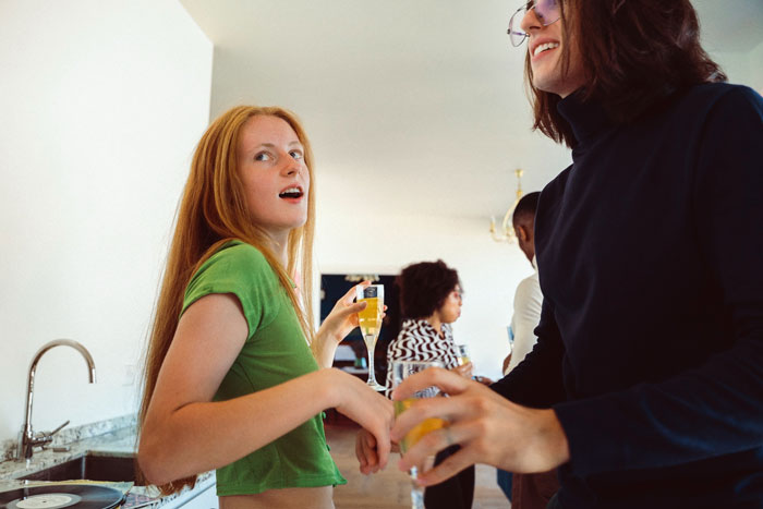 Young adults socializing at a party, illustrating the adopted sis chosen one joke backfiring family story. Young adults socializing at a party, illustrating the adopted sis chosen one joke backfiring family story.