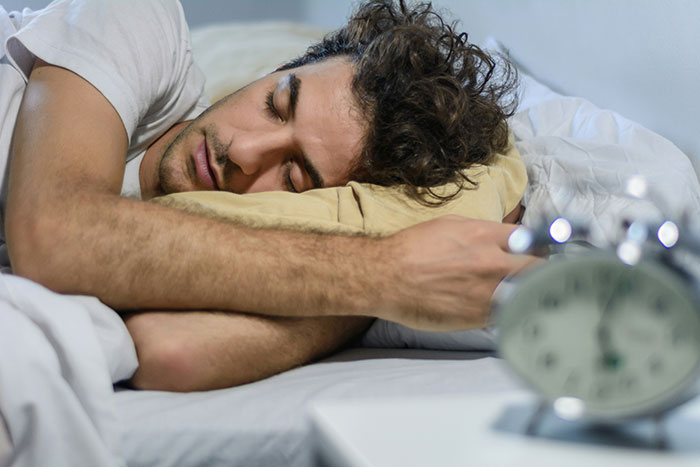 Man resting in bed with eyes closed, symbolizing a man who hasn't slept in 2 years and his medical condition.