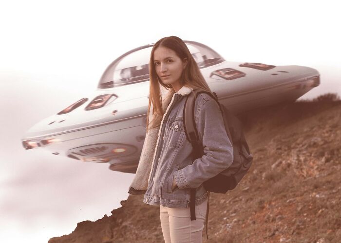 Young woman with backpack standing near a UFO on a rocky hill, illustrating terrifying space facts and fears.