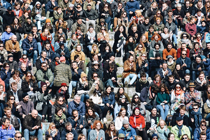 Large diverse crowd sitting outdoors on stone steps, illustrating how space is a lot scarier than we think.
