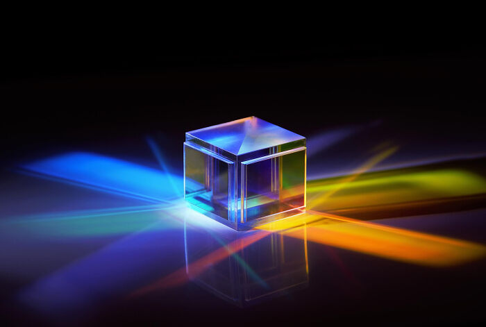 Transparent glass cube refracting colorful light beams, illustrating how space is a lot scarier than we think concept.