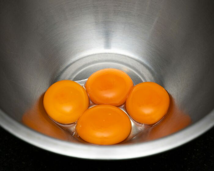 Four egg yolks in a metal bowl representing totally safe things that people can’t stop freaking out about, according to netizens