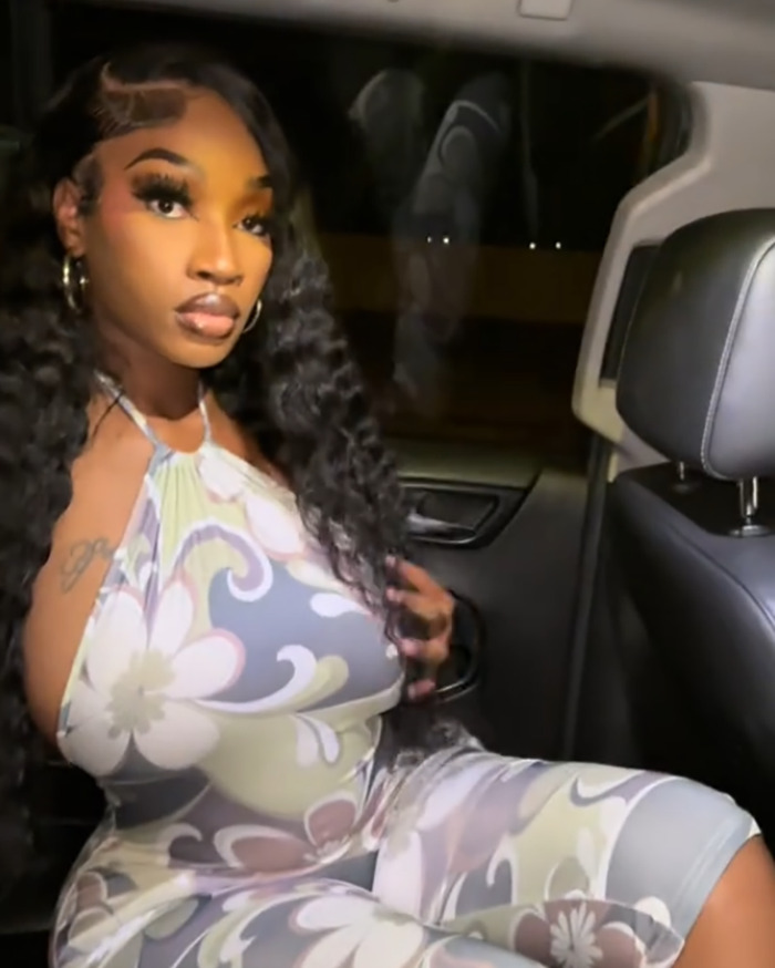 Teacher sitting in a car wearing a floral outfit, sparking viral debate over showing off curves for back-to-school.