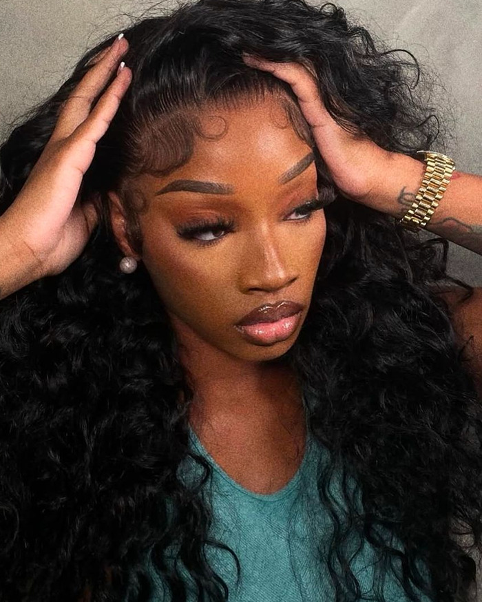 Young woman with long curly hair and gold watch, styled and posed for back-to-school teacher viral debate.