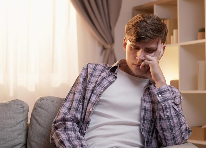Young man looking thoughtful and concerned indoors, reflecting on sister's boyfriend and his possibly fake behavior. - 14