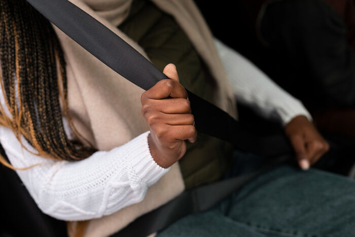 Person buckling seatbelt in a car, symbolizing childhood memories that felt sweet but became unsettling in retrospect.