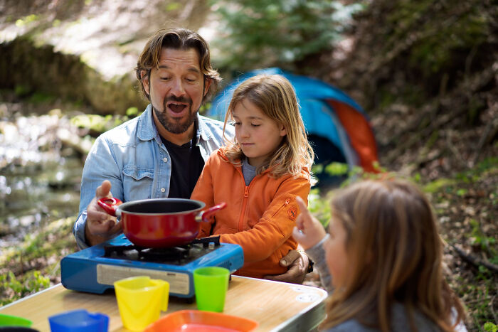 Man and children camping outdoors, sharing childhood memories that once felt sweet but became unsettling in retrospect.