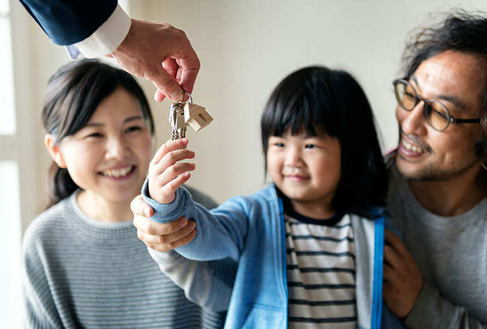 Family receiving house keys symbolizing a hot take on homeownership values shared with boomers.