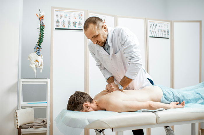 Chiropractor performing a back adjustment on a patient, illustrating common pseudoscience and wellness scams.