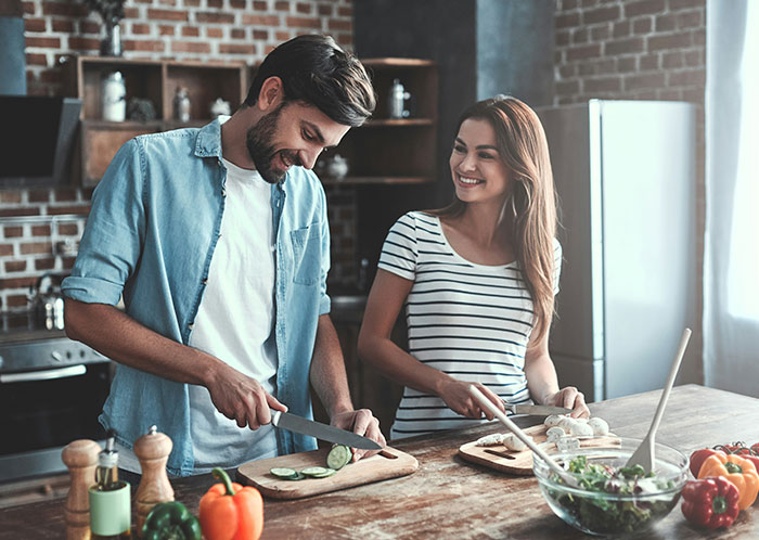 Couple preparing vegetables together in a modern kitchen, enjoying moments that reflect post-marriage life surprises.