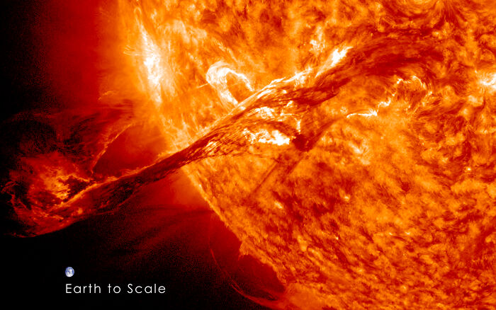 Solar flare erupts with immense power, illustrating a ticking big lifetime event with Earth shown to scale nearby.