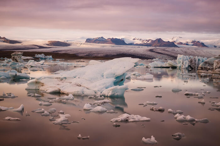 Melting icebergs floating in calm water under a cloudy sky, symbolizing ticking big lifetime event and climate change.