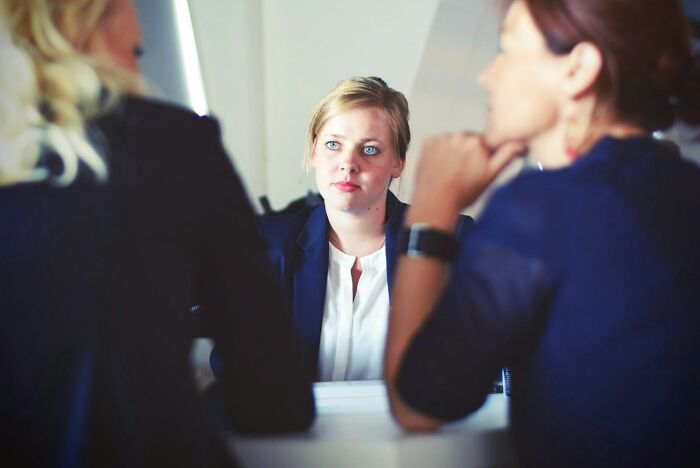 Young woman in a formal job interview setting, showing concern during discussion highlighting job interview red flags