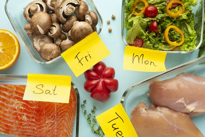 Weekly meal prep with labeled fresh vegetables, chicken, and salmon showcasing totally safe things people freak out about.