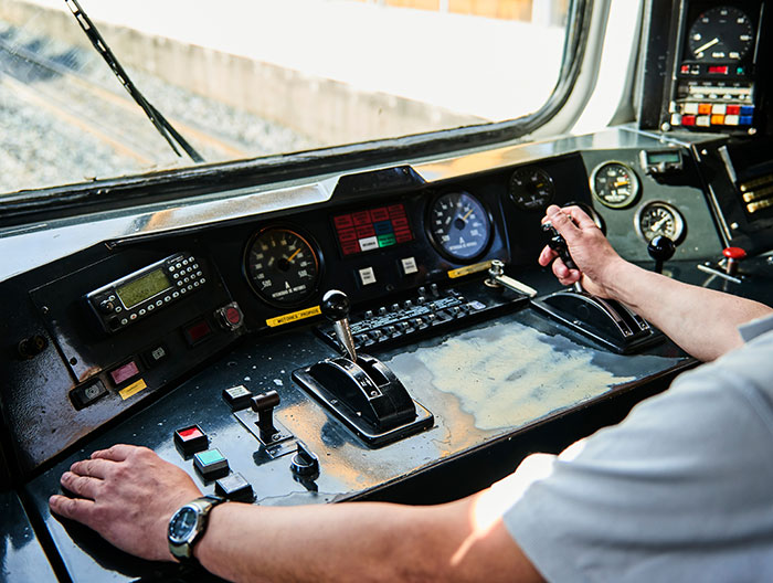 Man operating train controls showing hands on levers and dials, related to man who hasn't slept in 2 years medical mystery.