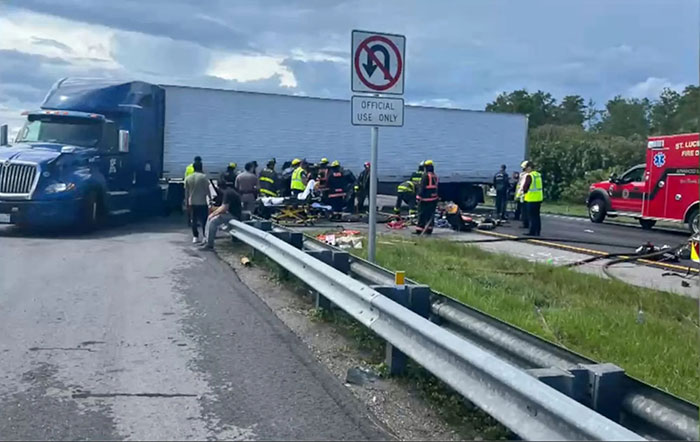 Emergency responders at the scene after a truck driver made an illegal U-turn causing a fatal accident with multiple victims.