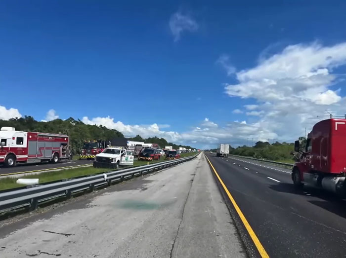 Emergency vehicles and a truck on a highway following a horrifying illegal U-turn accident involving a truck driver.