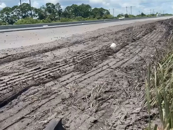 Deep tire marks on muddy roadside showing evidence of a truck driver&rsquo;s illegal U-turn that caused a fatal crash.