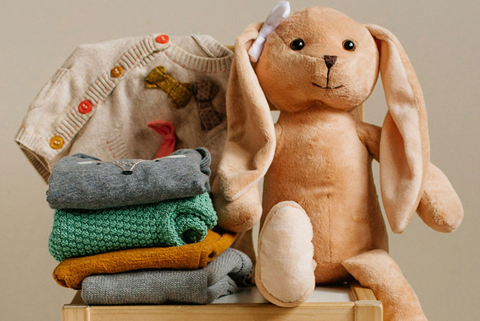 Stuffed bunny with long ears and a bow sits next to folded clothes, evoking a spooky and eerie encounter feeling.