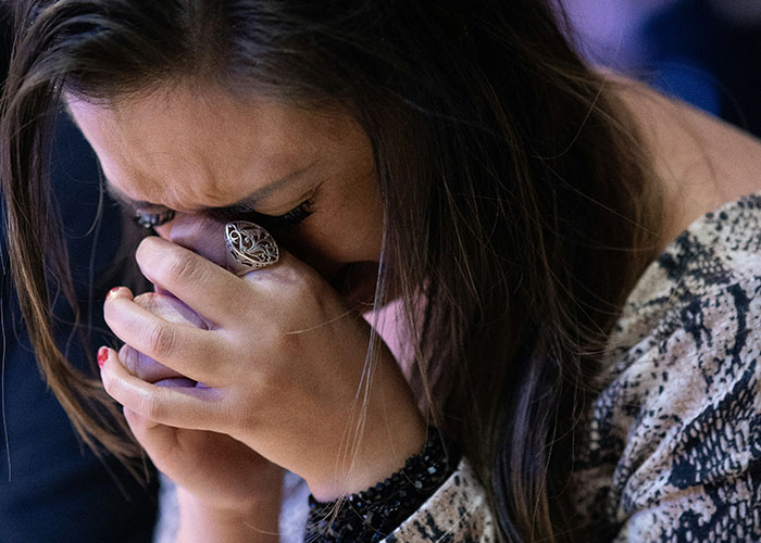 Woman covering her face with hands, visibly upset, illustrating reactions to unhinged things MILs said out loud.