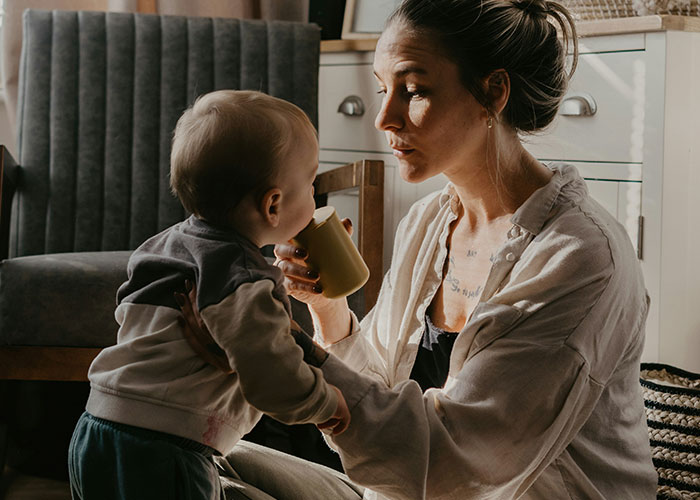 A mother feeding her baby, illustrating family moments related to unhinged things MILs thought were appropriate to say.