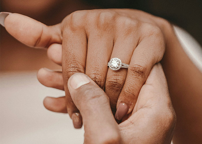 Close-up of hands showing an engagement ring symbolizing unhinged things MILs thought were appropriate to say about relationships.