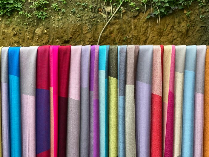 Colorful fabrics hanging outdoors, illustrating creative and strange money-making hacks people have actually pulled off.