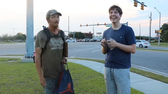 Two men talking casually on a roadside, showing contrast between relaxed and overcompensating alpha vibe traits. - 18