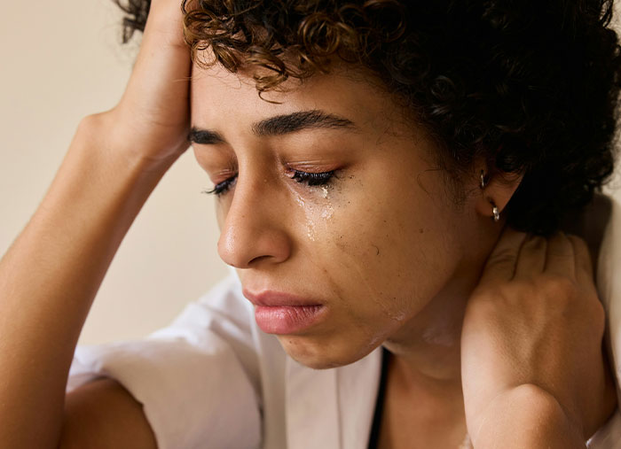 Close-up of a distressed Walmart employee with tears, showing emotional moments from wild times at work.