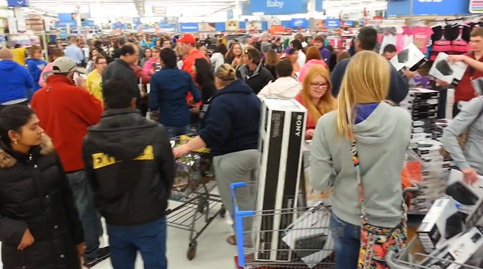 Crowded Walmart store with busy employees and shoppers during a chaotic shift making Walmart employees think they don’t get paid enough.