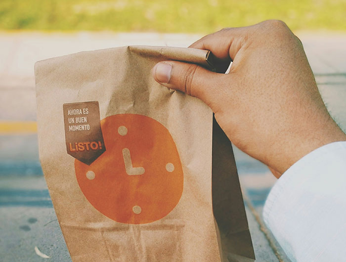 Walmart employee holding a brown paper bag with a clock logo, illustrating wild times and work challenges.