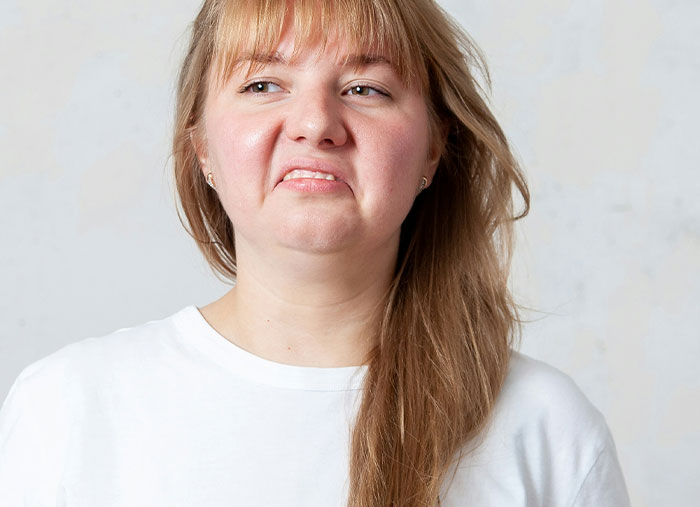 Woman in white shirt making a disgusted face, representing Walmart employees thinking I don’t get paid enough for this.