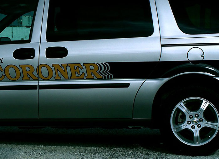 Side view of a coroner vehicle parked outside, illustrating unusual situations Walmart employees faced at work.