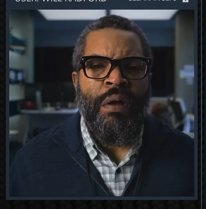 Ice Cube portraying a serious character in a scene from War Of The Worlds with a dark background.