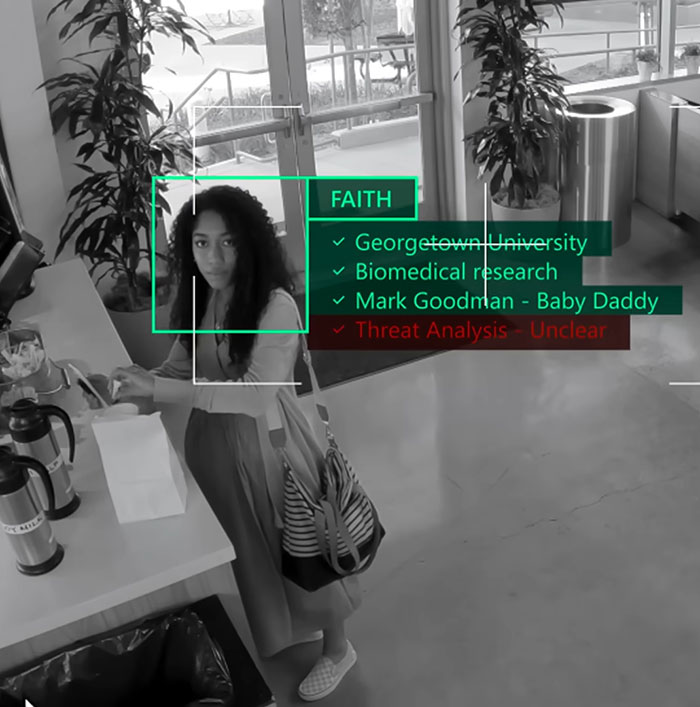 Woman identified with digital overlay analysis showing faith, education, and threat status in a modern indoor setting. - 4