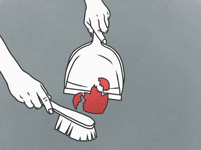 Hands sweeping broken red pottery pieces into a dustpan on a gray background, symbolizing real-life confessions water sign.