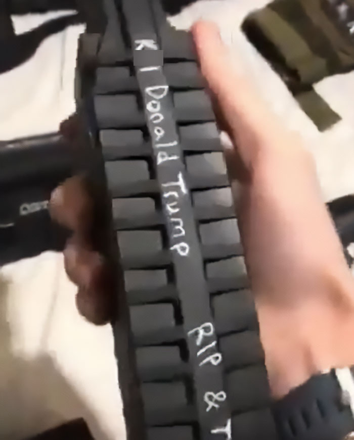 Hand holding a firearm magazine with disturbing writing linked to Minneapolis massacre culprit's manifesto and photos.