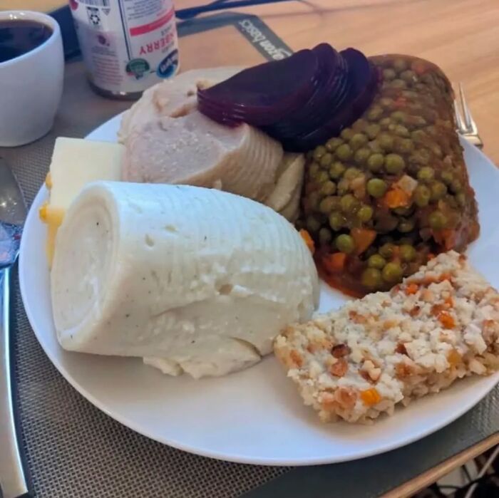 Plate of molded peas, gelatin, sliced beets, and other unusual food items from a cursed images Instagram page.