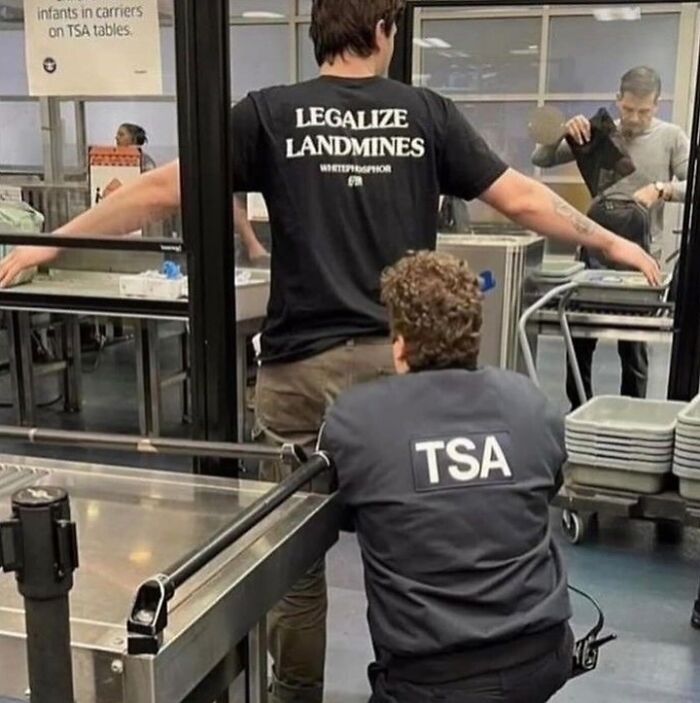 Man being frisked by TSA agent in an airport security area, a cursed image showing an unusual security check pose