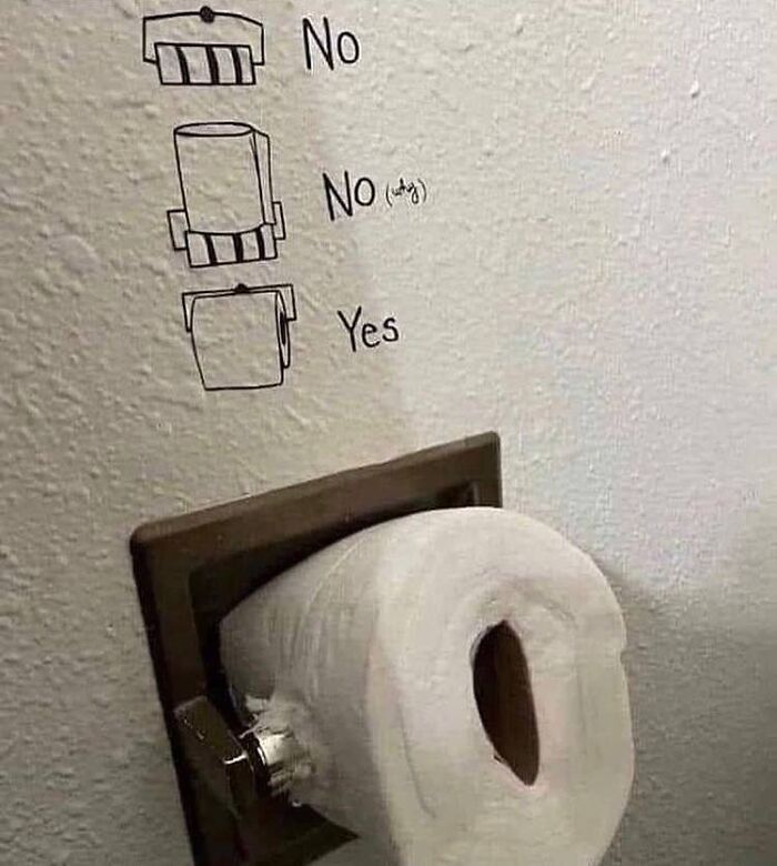 Toilet paper orientation guide drawn on wall above toilet paper roll, a cursed image from popular Instagram page disturbing fans daily