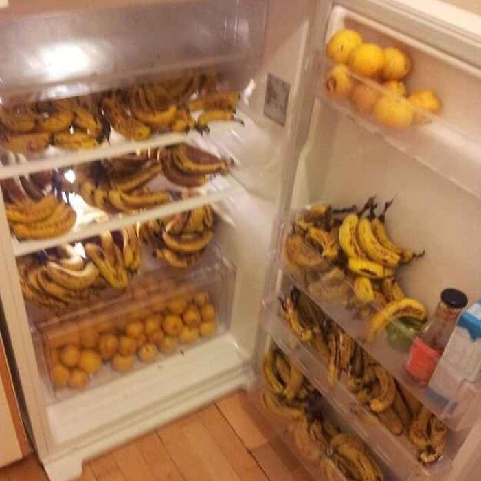 Open fridge filled with numerous overripe bananas and some oranges, illustrating cursed images from an IG page.